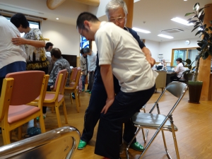 介助する人は前回のボディメカニクスを思いだし、足を広げて、安定した姿勢でかまえ、また介助される人はしっかり前かがみになり、自然と腰の浮く姿勢になることで、お互いに負担の少ない動きで立つことができました。